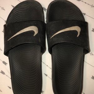 Black Nike slides.